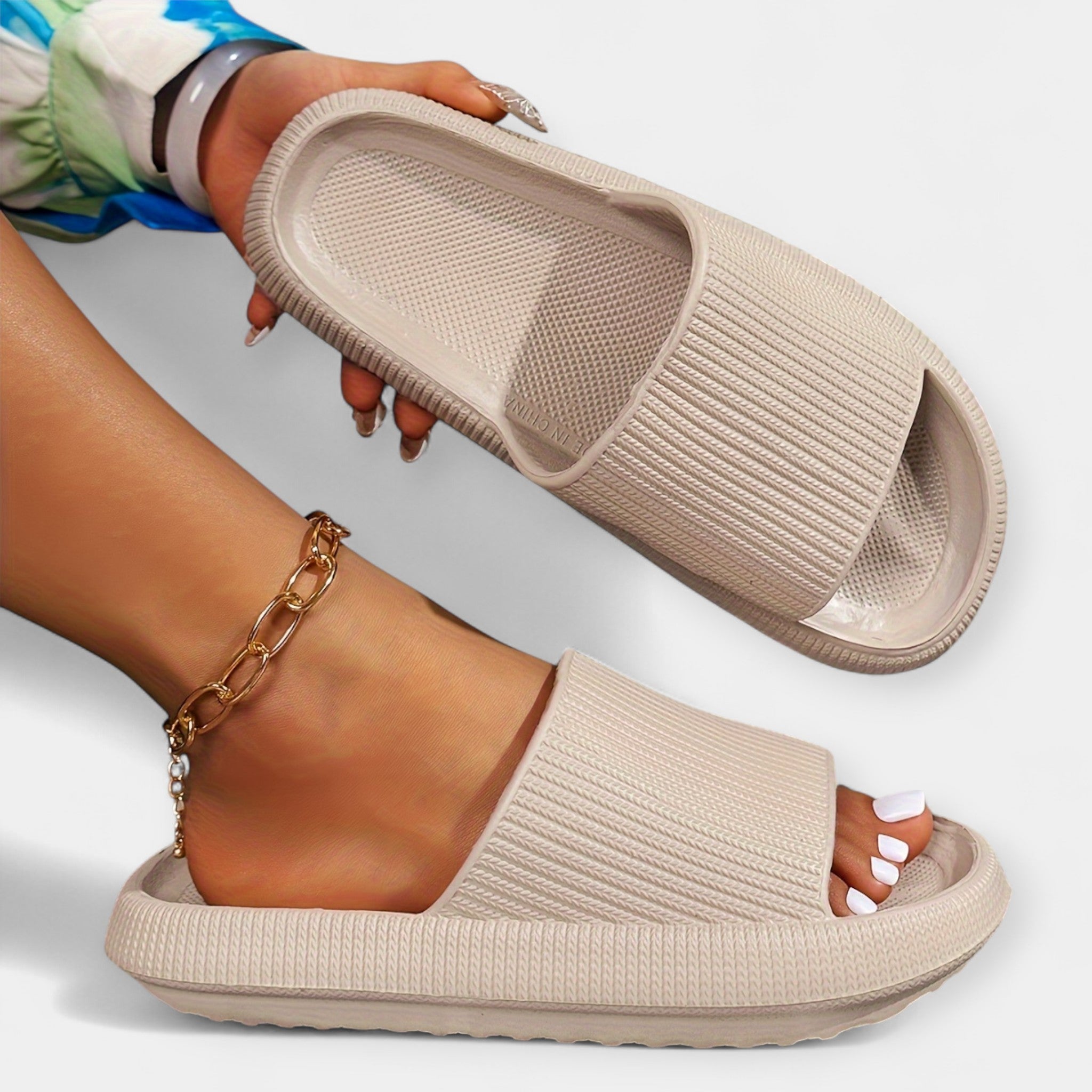 Beige slide sandals with textured strap, open toe, and cushioned sole