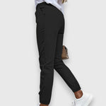 High-waisted black dress pants with tapered legs and cuffed ankle, close-up
