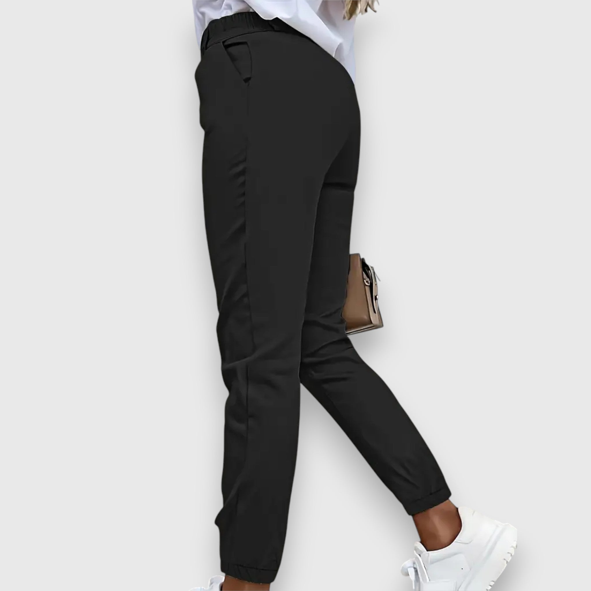 High-waisted black dress pants with tapered legs and cuffed ankle, close-up