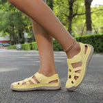 Light summer sandals on feet, yellow straps with adjustable buckle and textured rubber sole