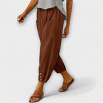 Brown harem pants with side pockets and button-tab cuffs, relaxed loose fit