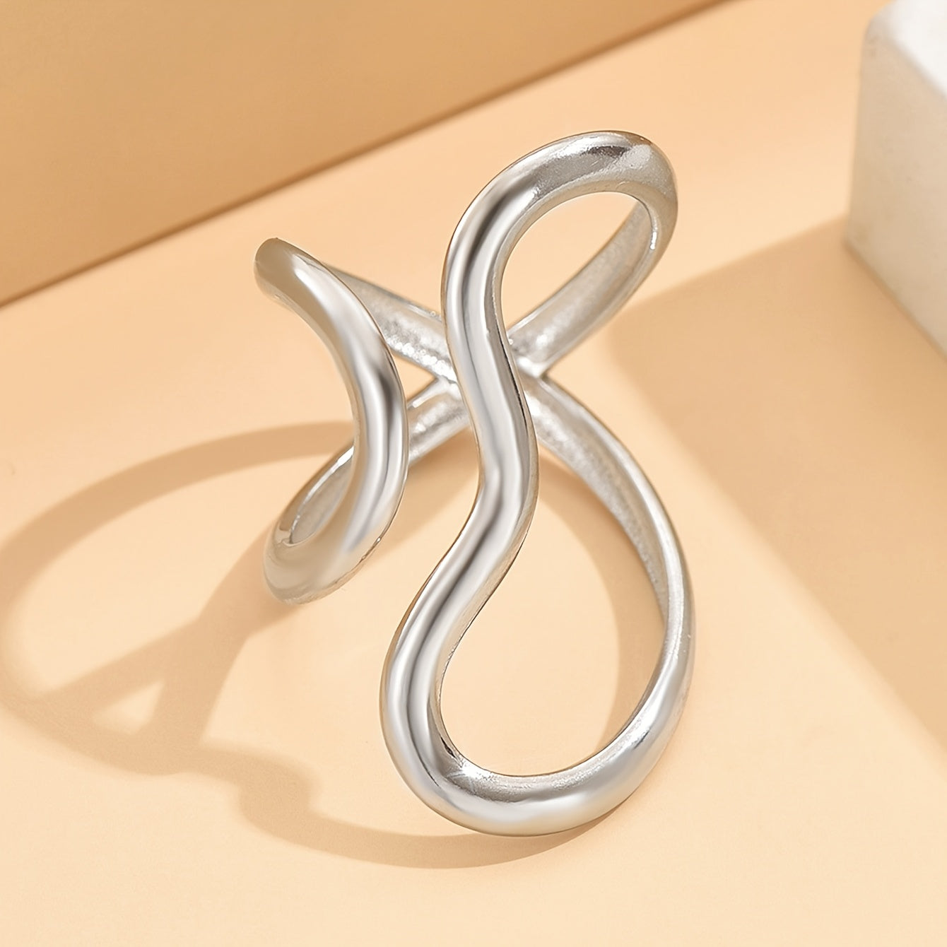 Silver-tone asymmetric wave statement ring with curled open-loop design