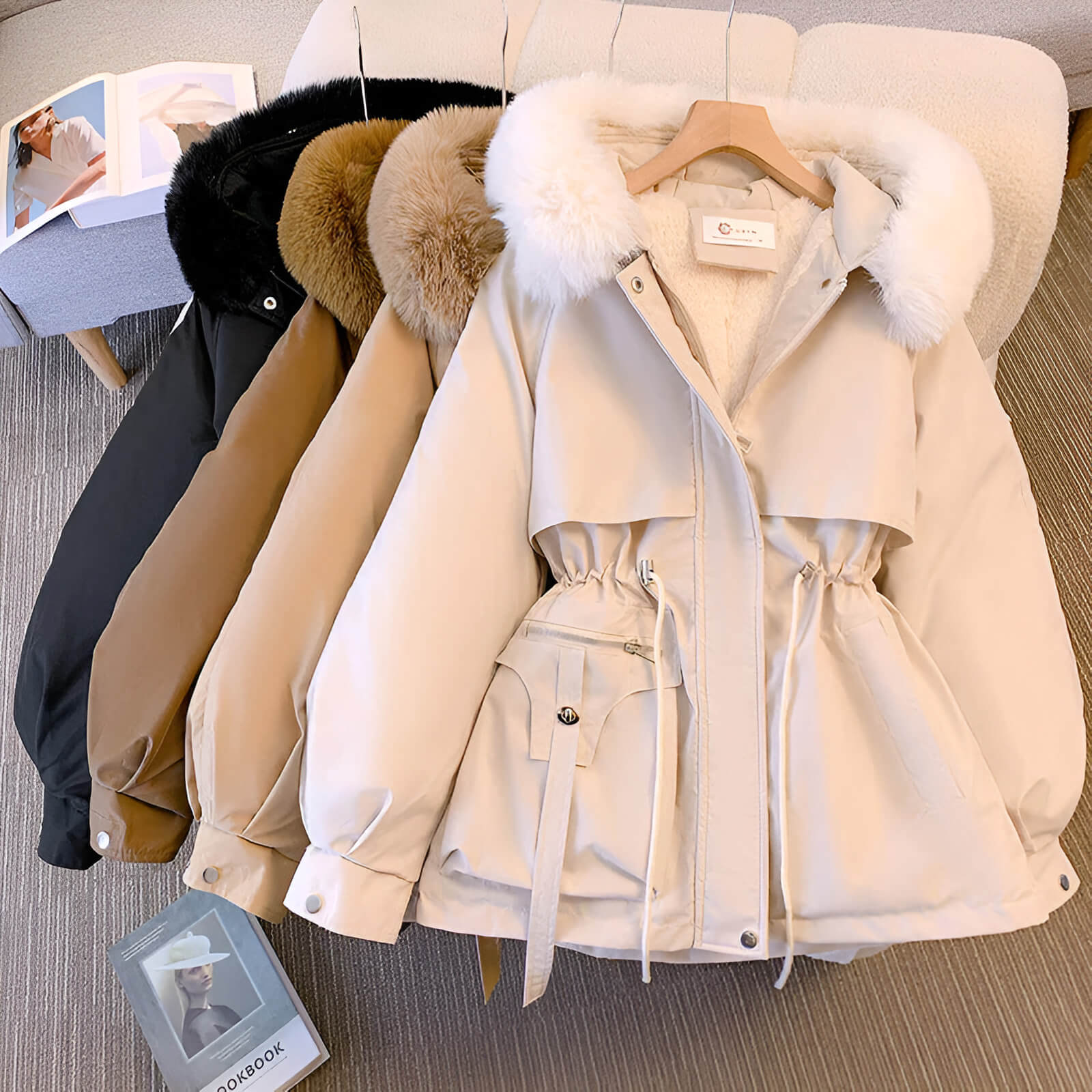 Fur-trimmed hooded puffer jackets in black, tan, and beige on hangers