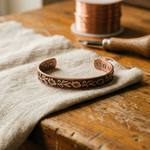 Adjustable copper bracelet with engraved floral pattern and rounded end links