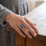 Vintage silver ring with oval blue gemstone worn on hand