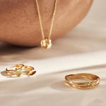 Gold-tone multi-band ring resting on a tabletop