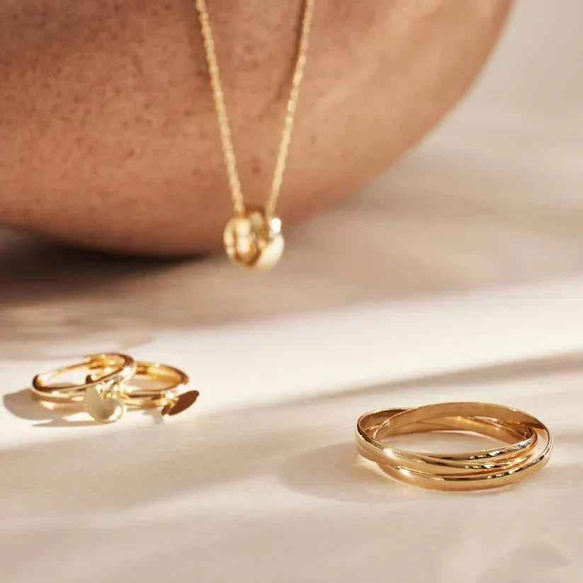 Gold-tone multi-band ring resting on a tabletop