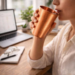 Copper 350 ml simple mug in hands, close-up indoors