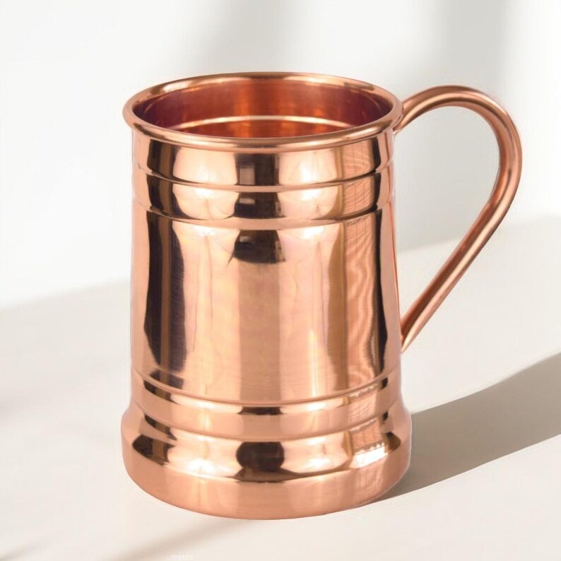 Copper mug with handle and ridged design, close-up front view