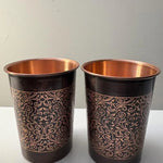 Two copper mugs with gold floral scroll pattern and copper interiors, dark bronze finish