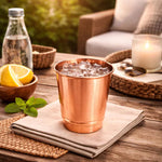 Copper 350 ml drinking cup with ice cubes and mint leaves on a napkin
