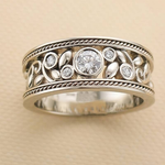 Silver-tone zircon ring with wide band, round center stone and small side stones