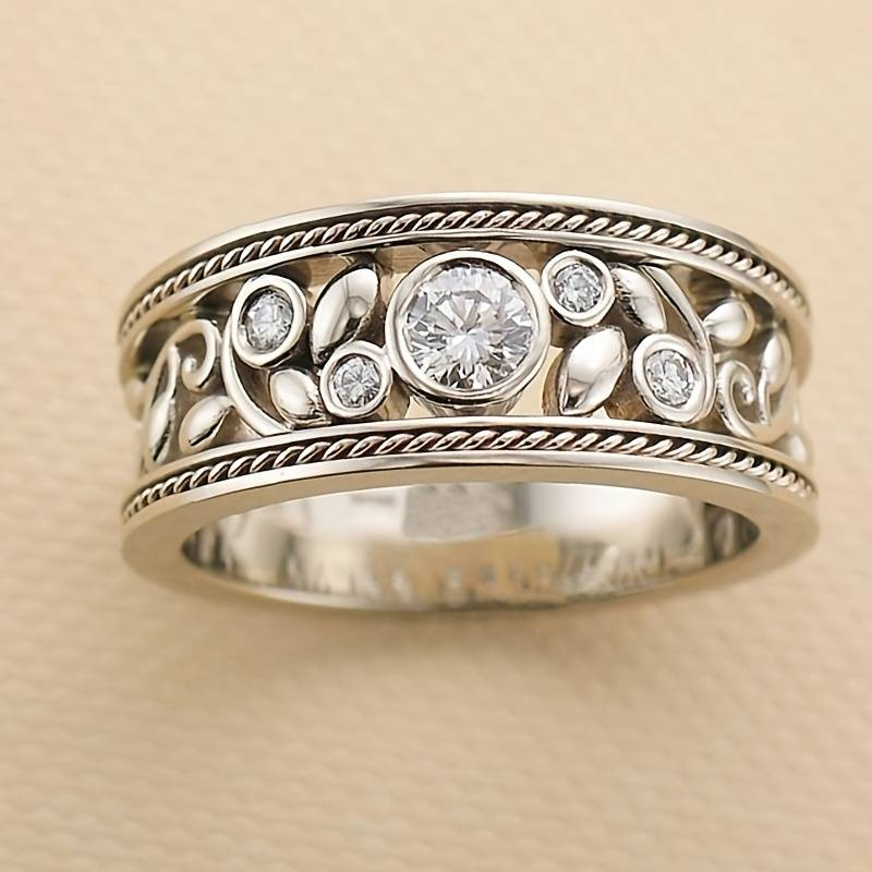 Silver-tone zircon ring with wide band, round center stone and small side stones