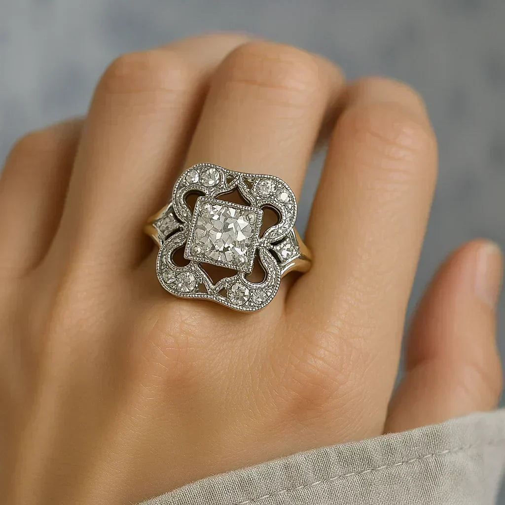 Vintage-style ring on hand with ornate silver frame and square clear center stone, glittering edges