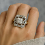 Vintage-style ring on hand with ornate silver frame and square clear center stone, glittering edges