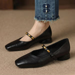 Black leather ballet flats with rounded toe, low block heel, and gold buckle strap