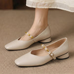 Cream leather ballet flats with rounded toe, low block heel, and gold buckle strap