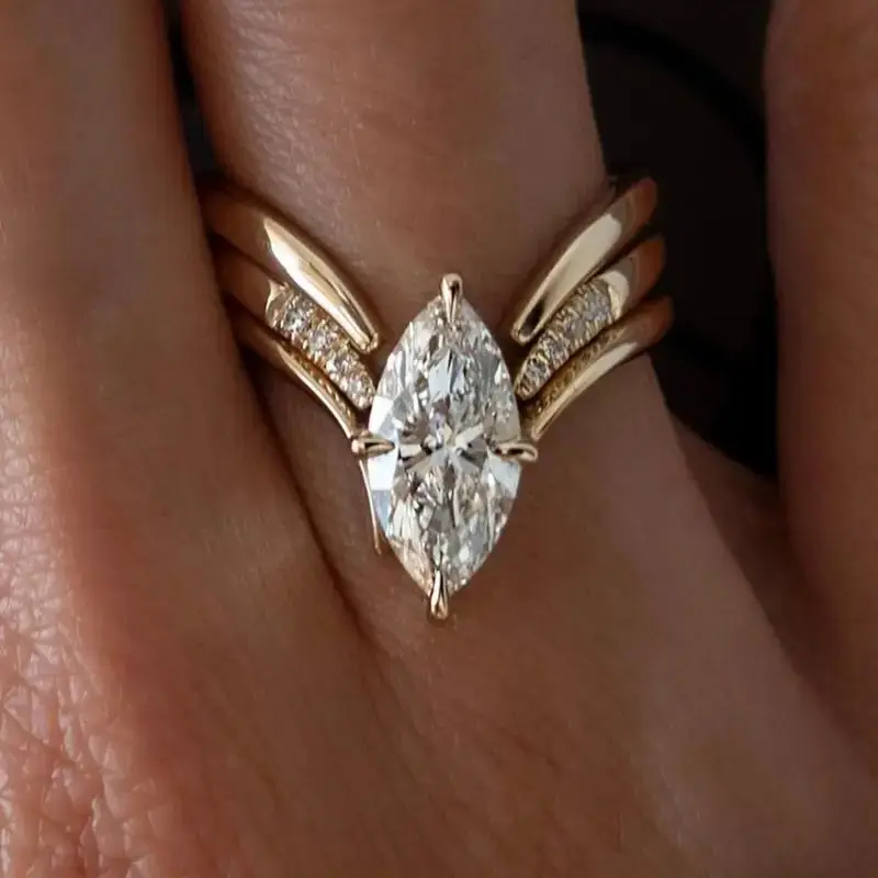 Gold ring with marquise-cut center stone and pavé side accents