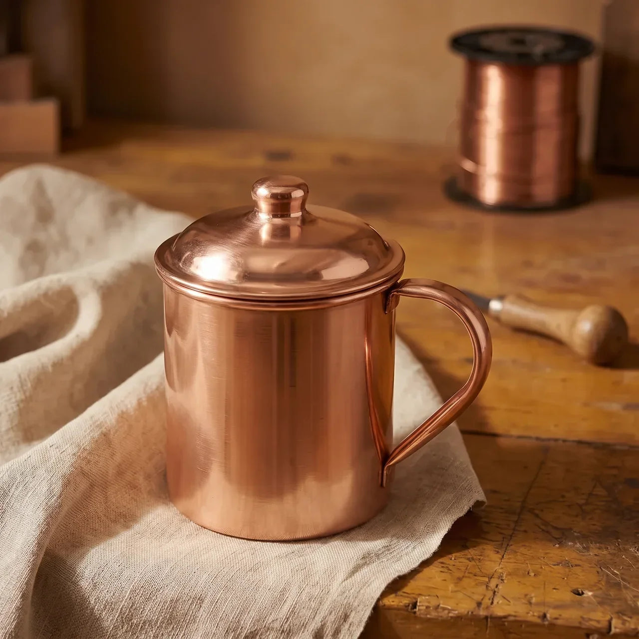 Hand-beaten copper jug with domed lid and side handle, polished finish