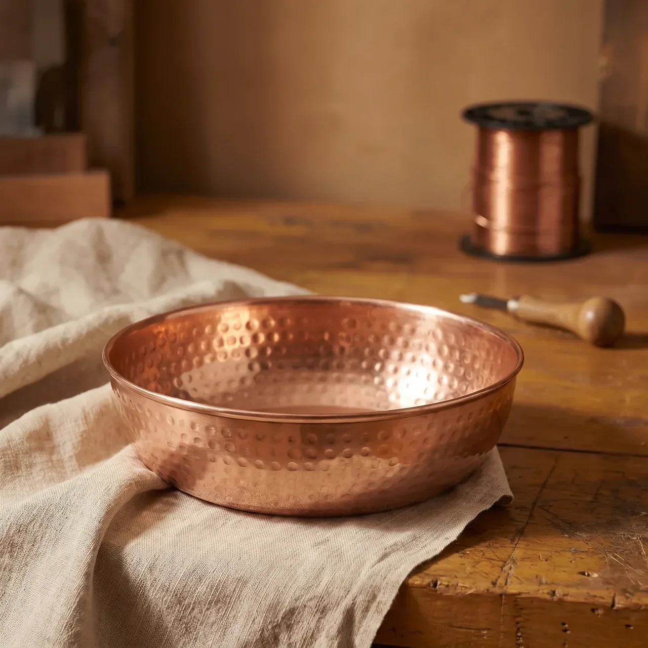 Hand-hammered copper serving bowl with rounded sides and hammered texture.