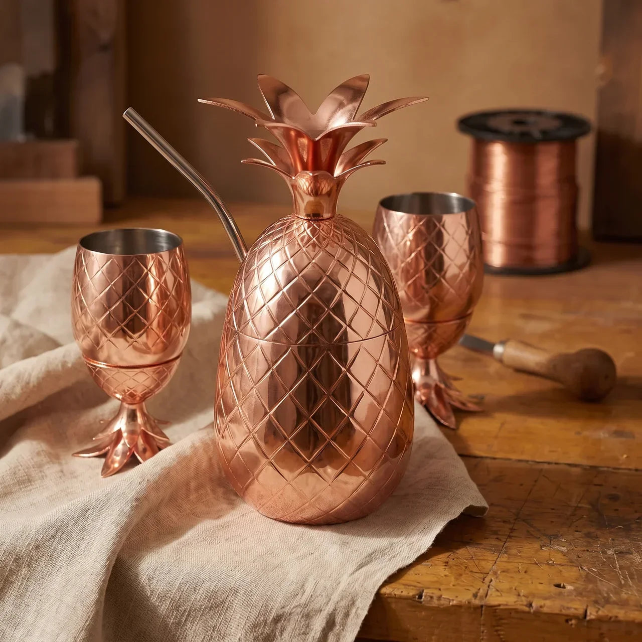 Copper pineapple-shaped cups and matching pitcher with hand-beaten diamond pattern