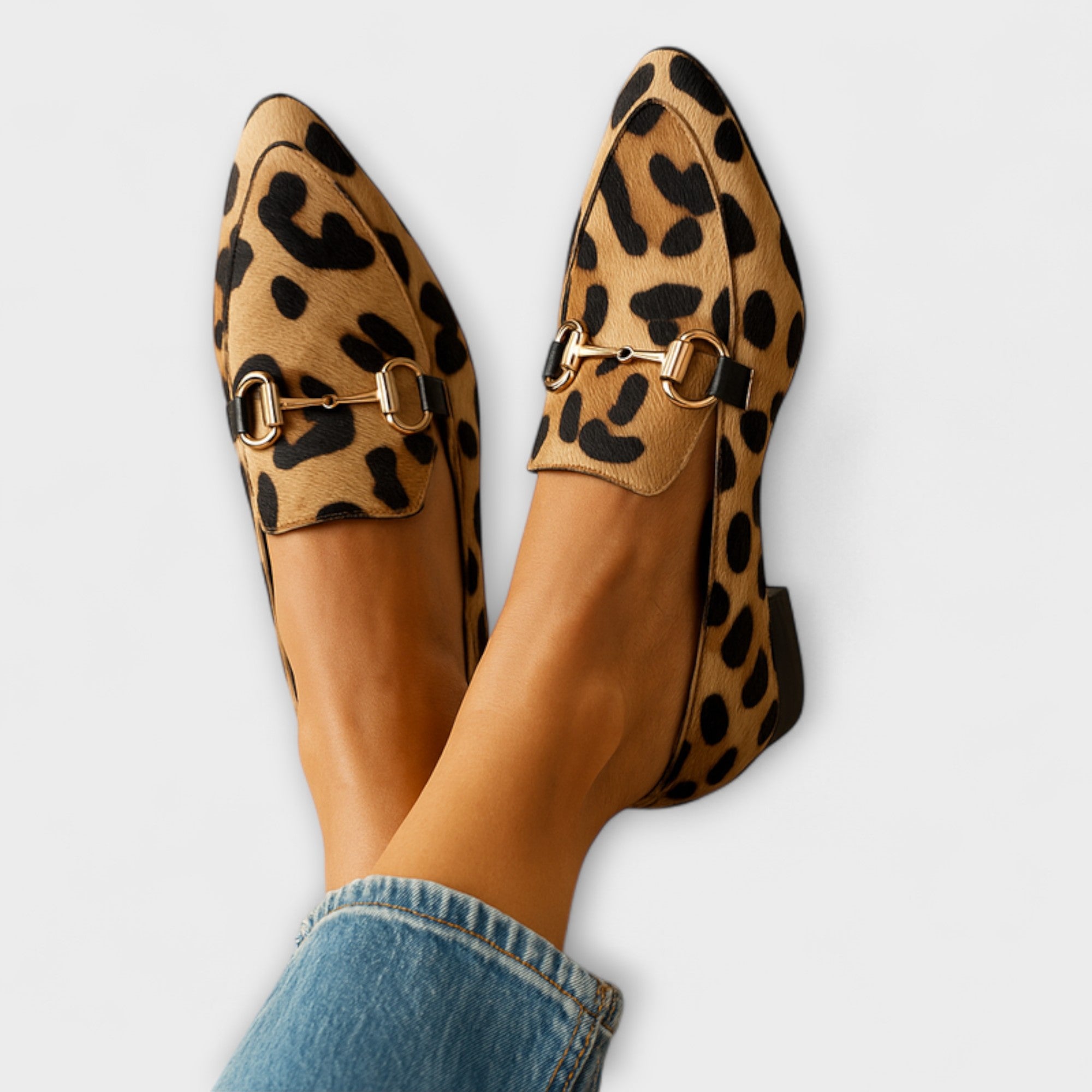 Leopard print loafers with gold metal buckle strap and classic moccasin style.