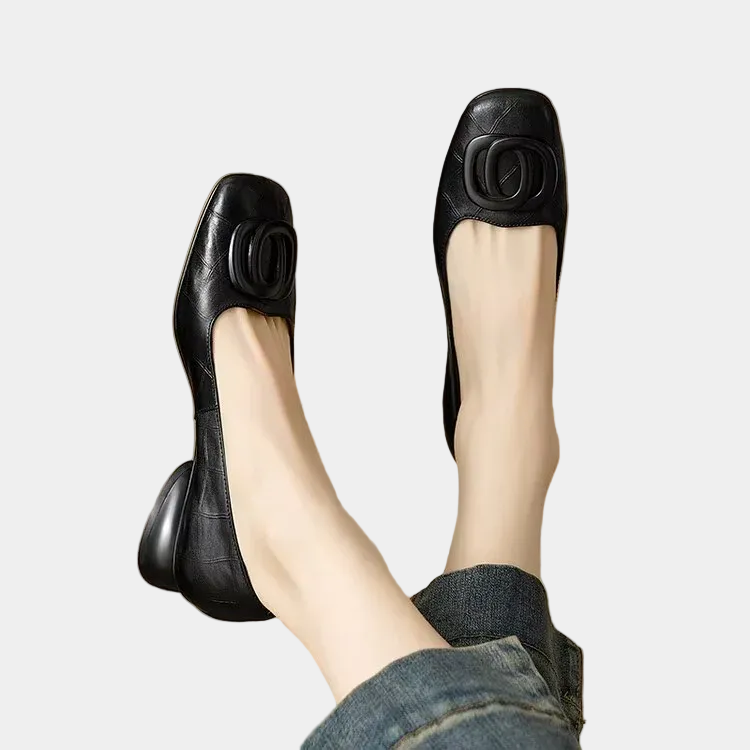 Black soft leather ballet flats with round buckle detail, low-profile sole