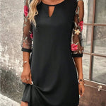 Black shift dress with cutout neckline, sheer floral sleeves, and draped hem