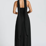 Women’s halter back maxi dress in black with open back straps and draped detail.