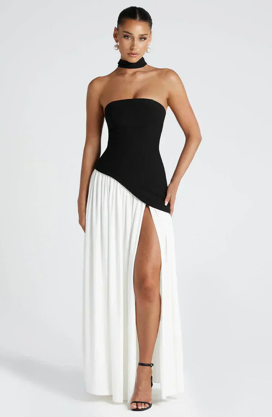 Women’s strapless maxi dress with black bodice and flowing white skirt, side slit.