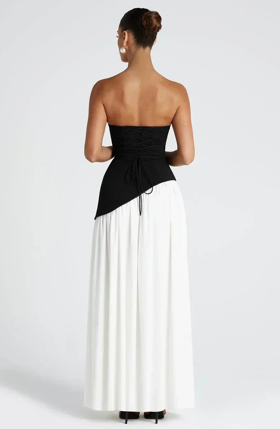 Women’s maxi dress with black lace-up bodice and white gathered skirt, back view.