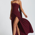 Burgundy strapless maxi dress with high leg slit and flowing cape-like back overlay