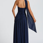 Women’s strapless navy maxi dress with open back and flowing skirt, draped side panel.