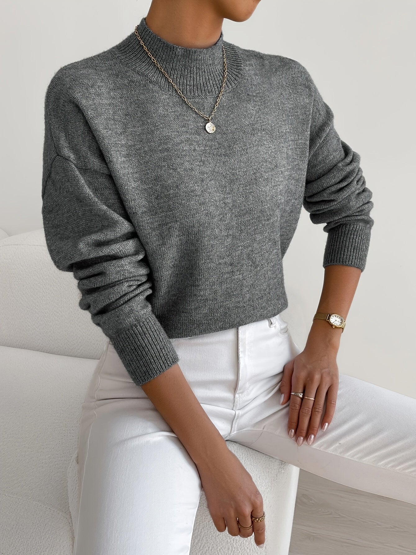 Dark gray knit crewneck pullover with long sleeves and ribbed cuffs