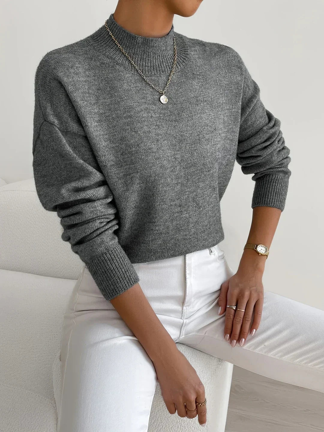 Women’s dark gray knit pullover with rolled neckline and long sleeves, relaxed fit.