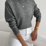 Women’s dark gray knit pullover with rolled neckline and long sleeves, relaxed fit.