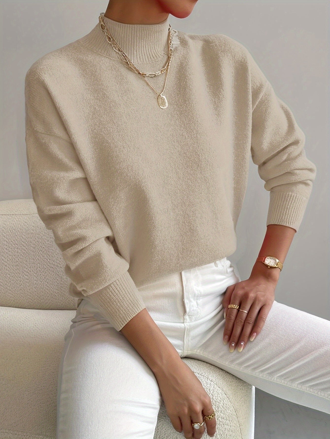 Beige knit crewneck pullover with long sleeves and ribbed cuffs