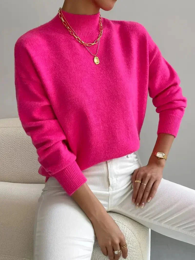 Women’s bright pink knit pullover with rolled neckline and long sleeves, relaxed fit.