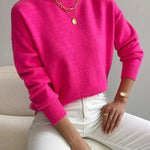 Women’s bright pink knit pullover with rolled neckline and long sleeves, relaxed fit.
