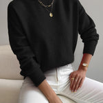 Black knit crewneck pullover with long sleeves and ribbed cuffs