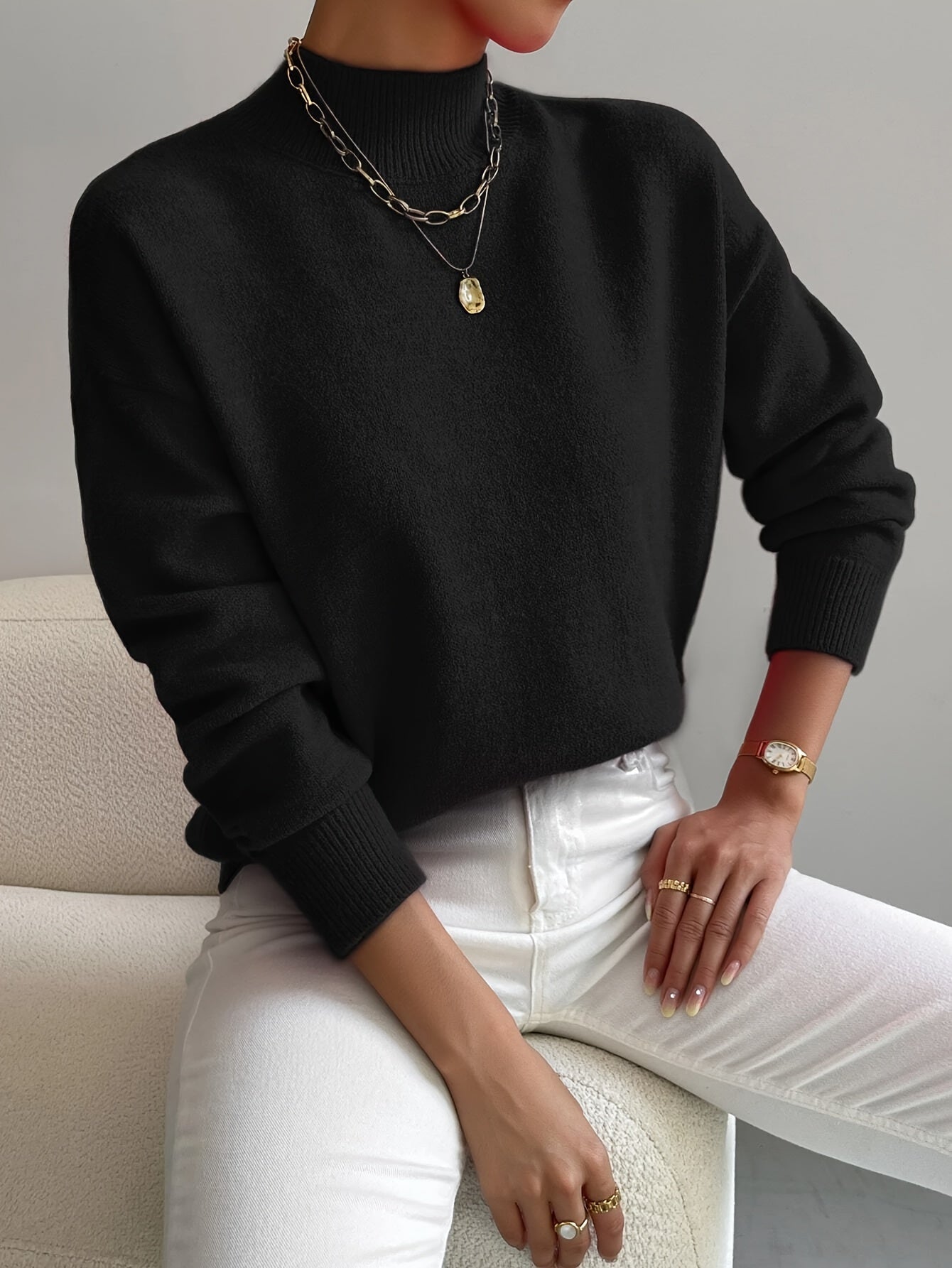 Black knit crewneck pullover with long sleeves and ribbed cuffs