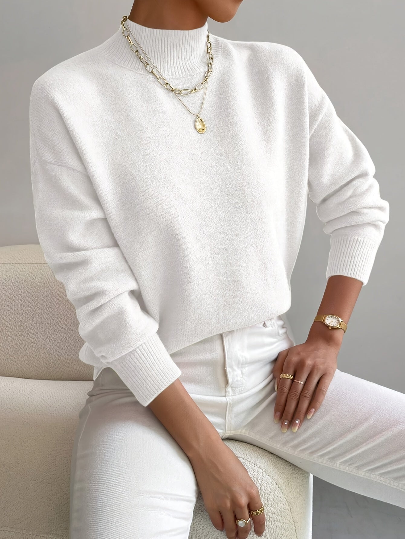 White knit crewneck pullover with long sleeves and ribbed cuffs