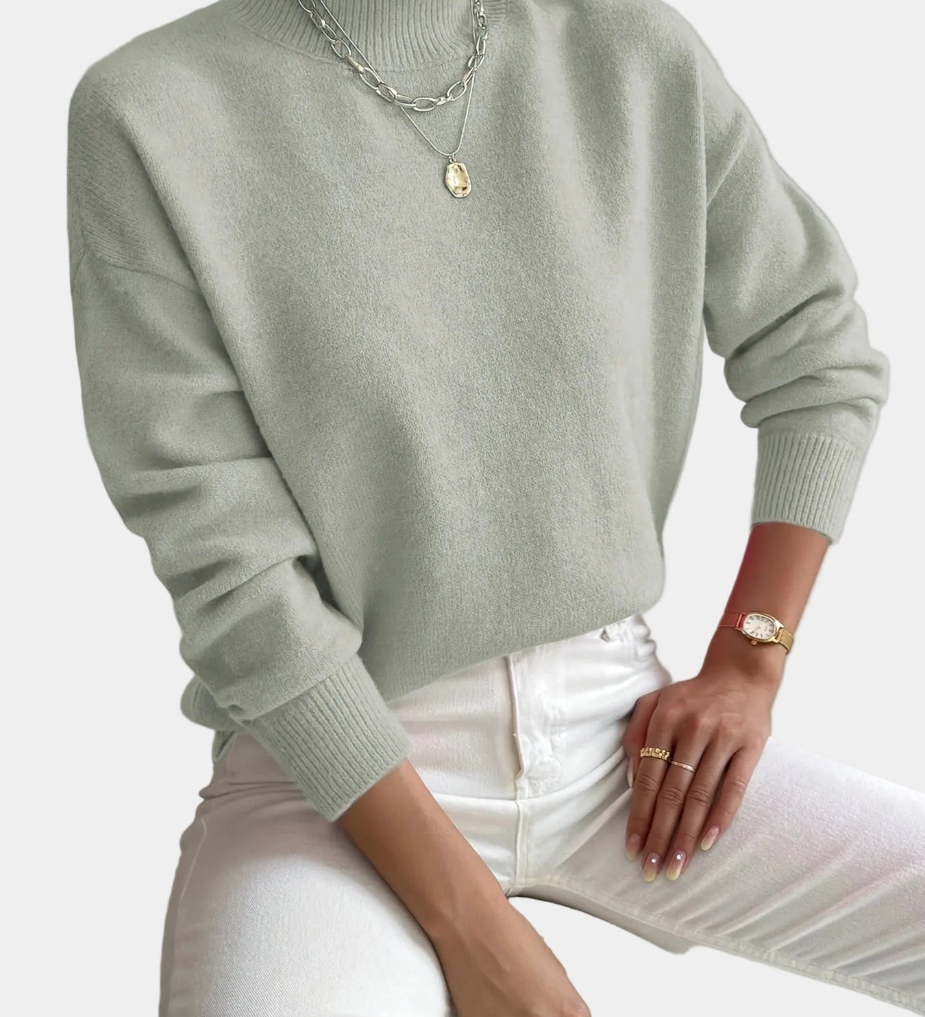 Women’s light sage knit pullover with rolled neckline and long sleeves, relaxed fit.
