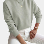 Women’s light sage knit pullover with rolled neckline and long sleeves, relaxed fit.