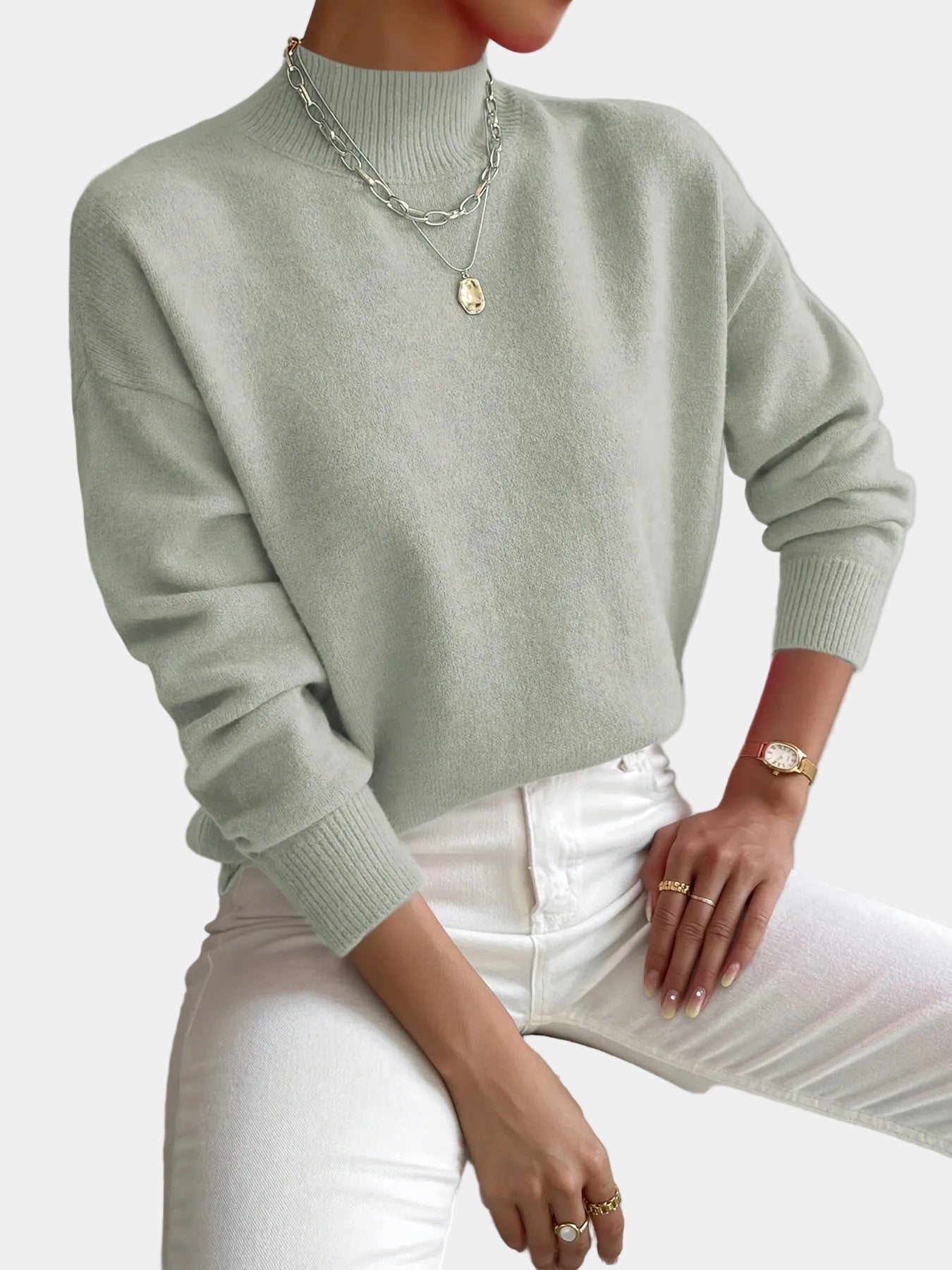 Women’s light sage knit pullover with rolled neckline and long sleeves, relaxed fit.