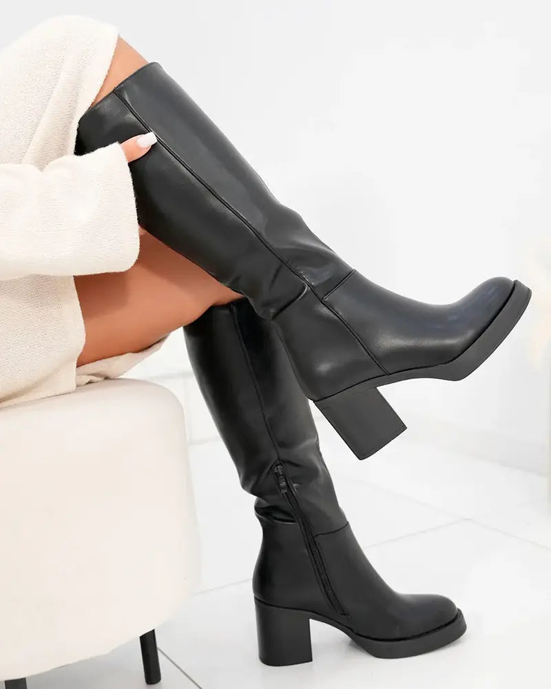 Black tall heeled boots with squared toe and chunky mid-heel, smooth leather