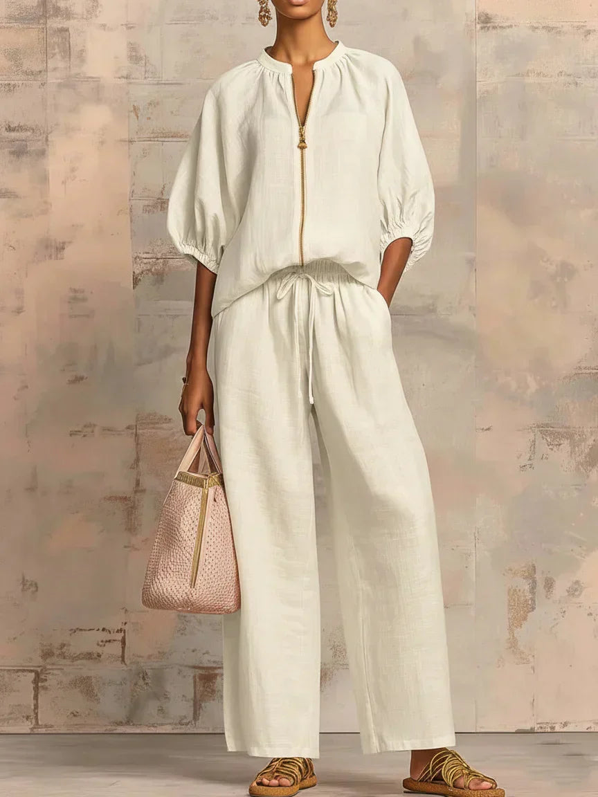 White two-piece blouse and wide-leg pants set with front zipper and gathered tie waist