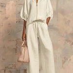 White two-piece blouse and wide-leg pants set with front zipper and gathered tie waist