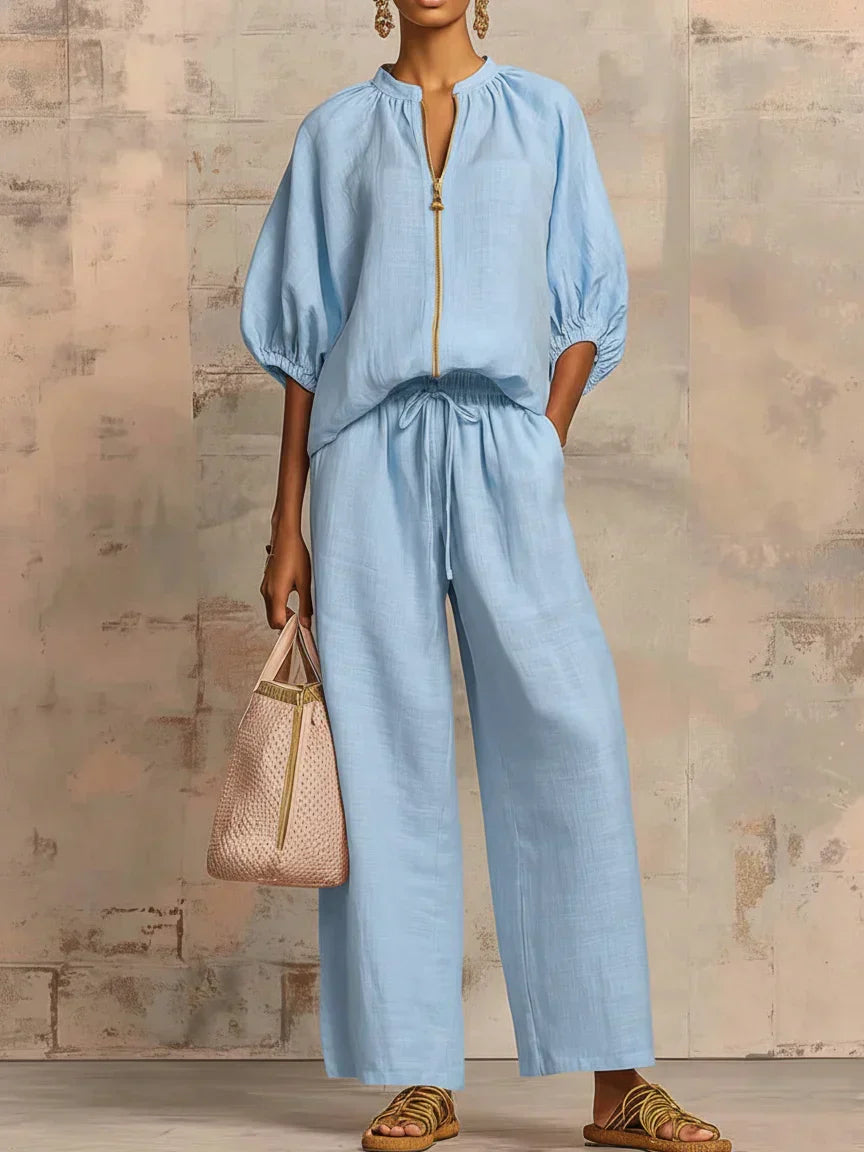 Light blue two-piece blouse and wide-leg pants set with front zipper and tie waist