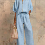 Light blue two-piece blouse and wide-leg pants set with front zipper and tie waist